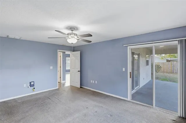wooden floor in an empty room and a ceiling fan