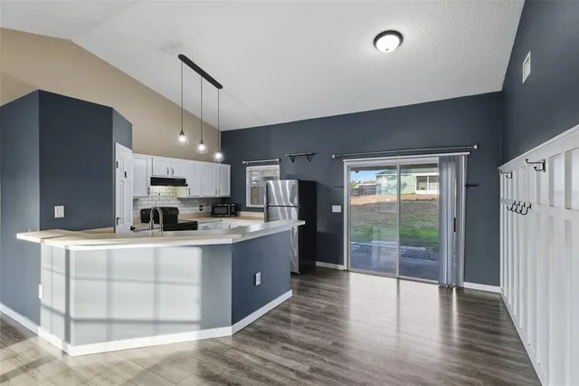 a large kitchen with kitchen island a large counter space a sink appliances and cabinets