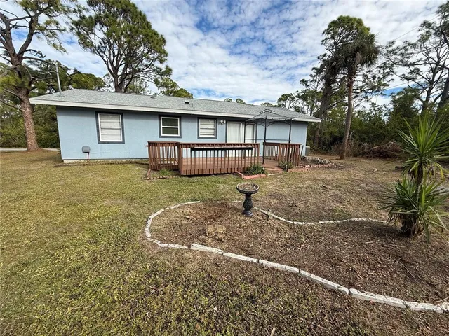 a view of a house with a backyard and a tree