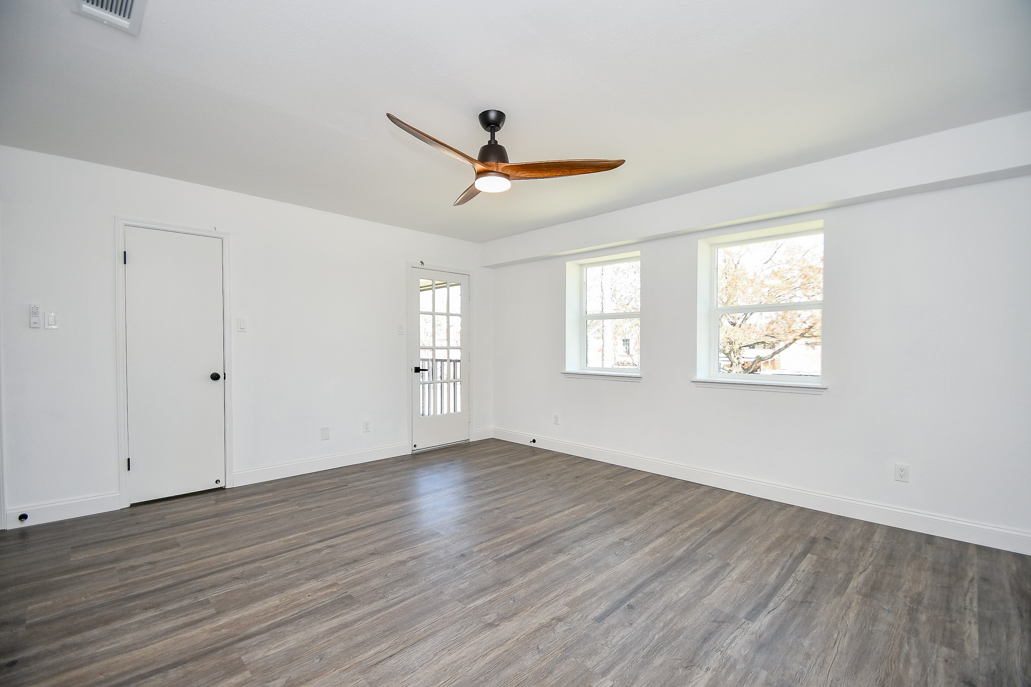 5801 Lumberdale Road, Unit 120 Houston, TX 77092 - Photo 27 of 45 an empty room with wooden floor ceiling fan and windows