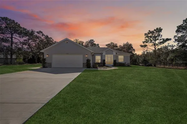 a front view of house with yard and green space