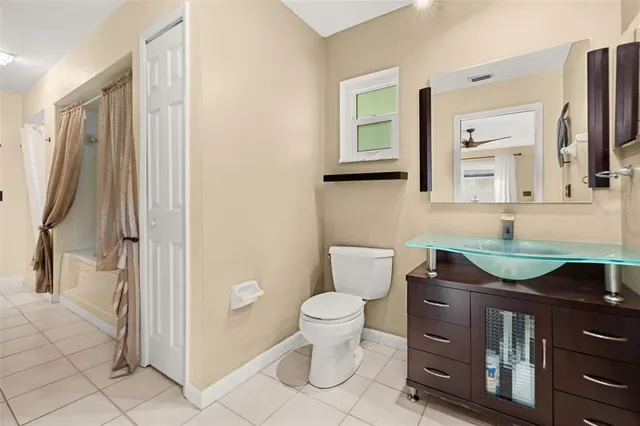 an aerial view of a tennis ground and a cars park side of the road