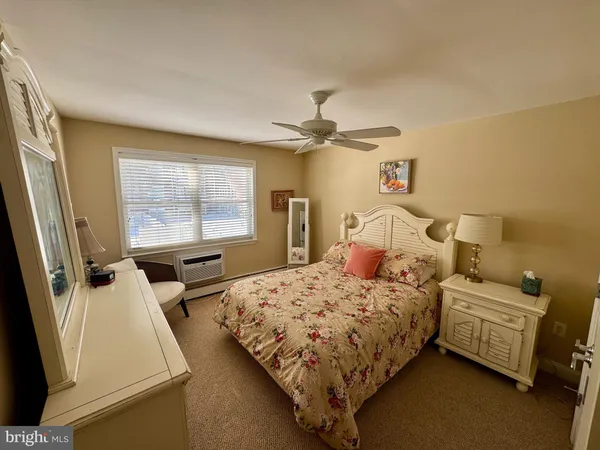 a bedroom with a bed and a flat tv screen on dresser