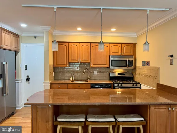 a kitchen with stainless steel appliances a stove a refrigerator and a microwave