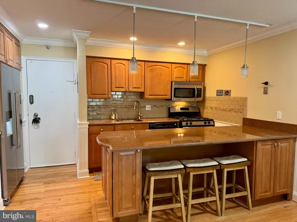 a kitchen with a stove a refrigerator and a microwave