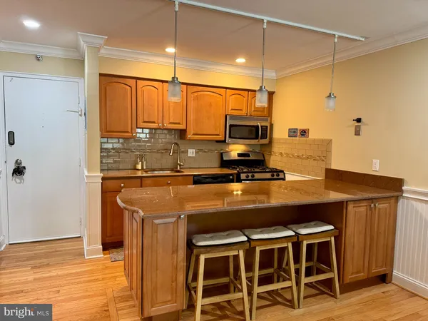 a kitchen with stainless steel appliances a stove a refrigerator and cabinets