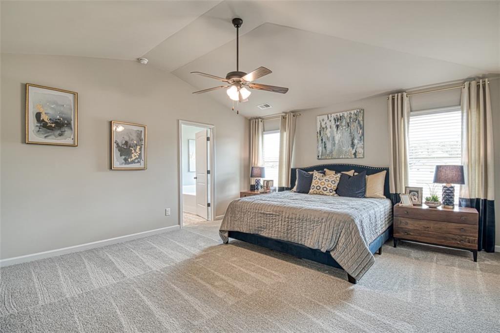 11951 Brightside Parkway Hampton, GA 30228 - Photo 18 of 25 a bedroom with a large bed and a chandelier