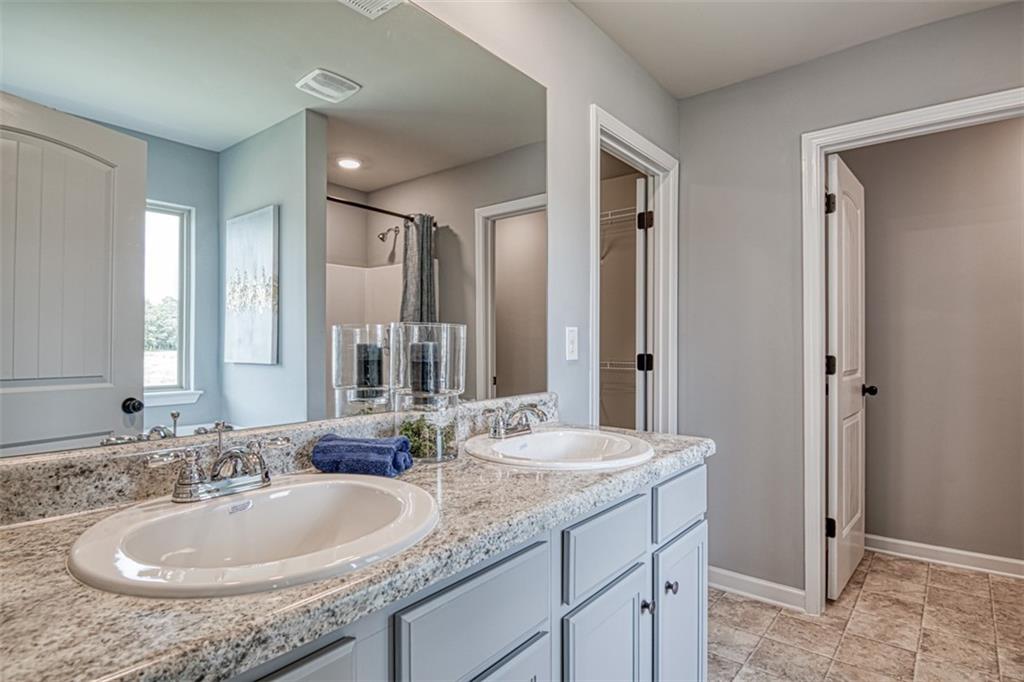 11951 Brightside Parkway Hampton, GA 30228 - Photo 20 of 25 a bathroom with a granite countertop sink and a mirror