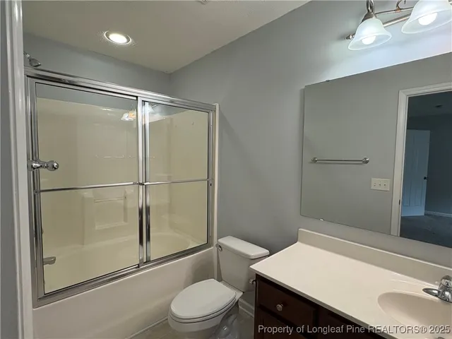 a bathroom with a granite countertop sink toilet a mirror and shower