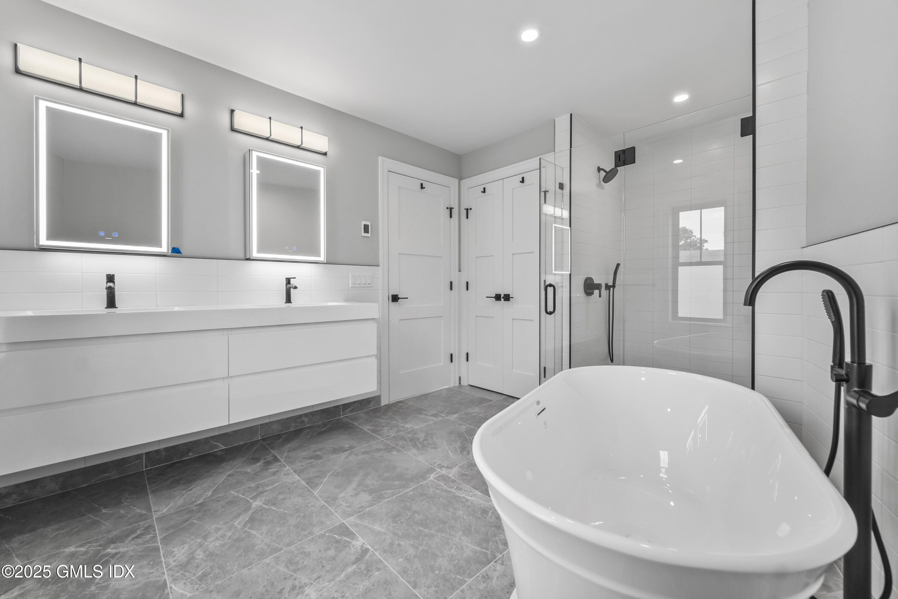 71 Old Field Point Road Greenwich, CT 06830 - Photo 18 of 33 a spacious bathroom with a bathtub shower sink and mirror