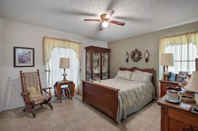 a bedroom with a bed a computer on the desk and chair