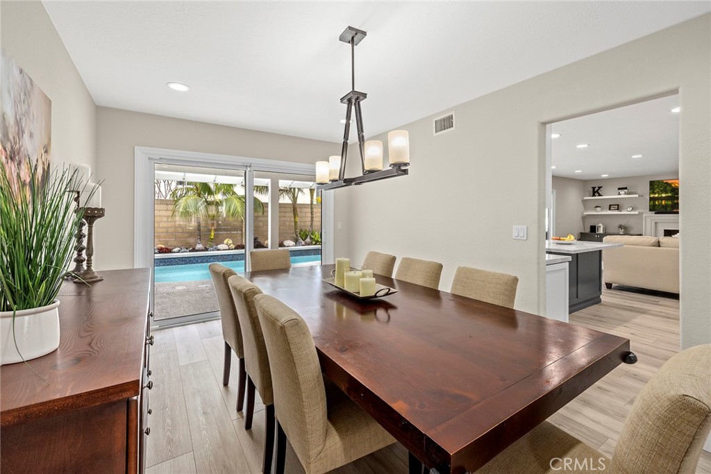 2352 Caper Tree Drive Tustin, CA 92780 - Photo 5 of 29 a view of a dining room and livingroom with furniture wooden floor a rug a potted plant and a chandelier