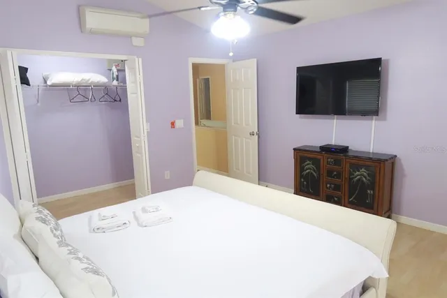 a bedroom with a bed and a flat screen tv