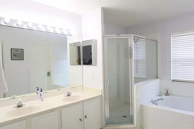 a bathroom with a tub a sink and mirror
