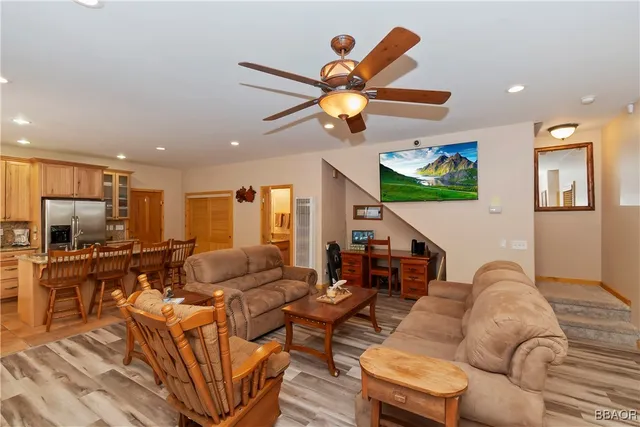 a living room with furniture kitchen view and a large window