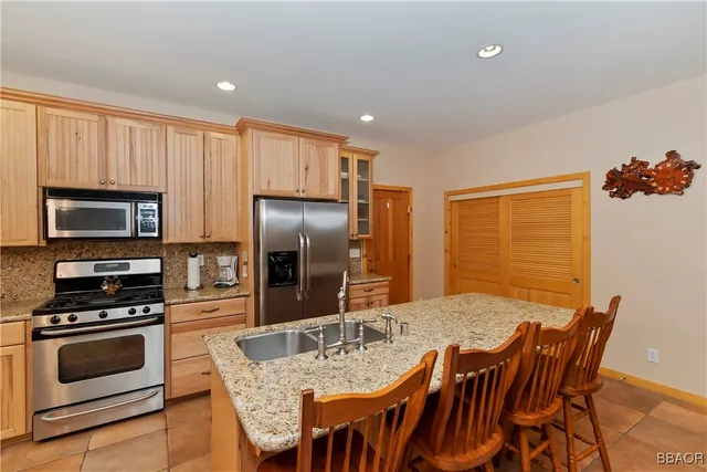 a kitchen with stainless steel appliances granite countertop a dining table and chairs