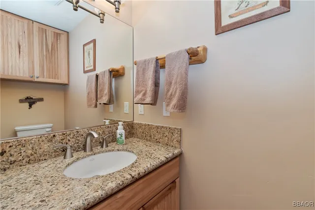 a bathroom with a granite countertop sink and a mirror