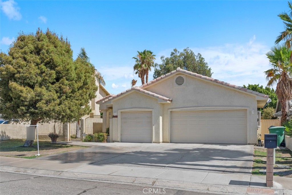 68744 Durango Road Cathedral City, CA 92234 - Photo 1 of 36 a front view of a house with a yard and garage