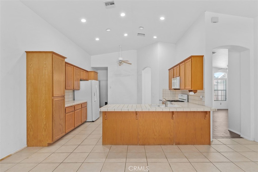 68744 Durango Road Cathedral City, CA 92234 - Photo 15 of 36 a large kitchen with stainless steel appliances a refrigerator and a stove