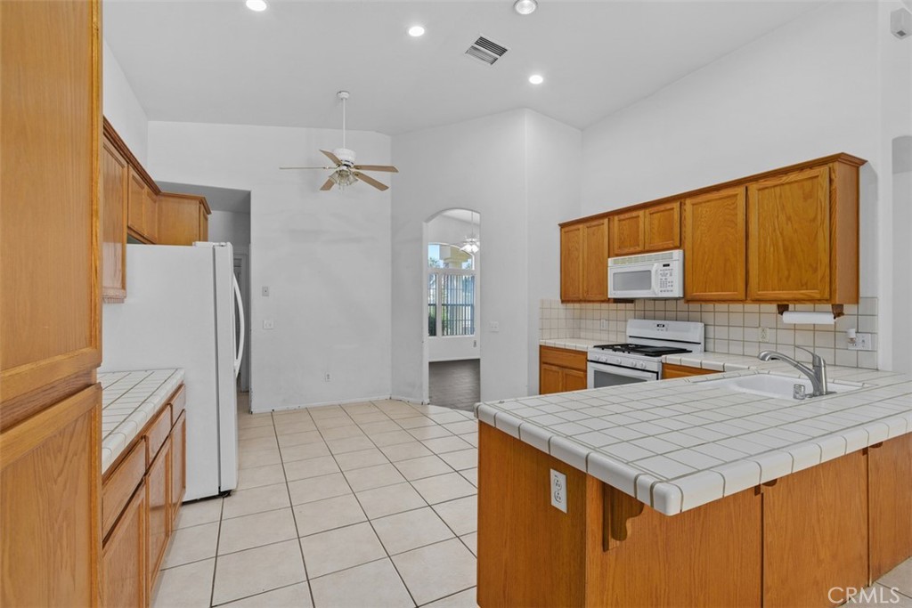 68744 Durango Road Cathedral City, CA 92234 - Photo 16 of 36 a kitchen with a stove a refrigerator and a sink
