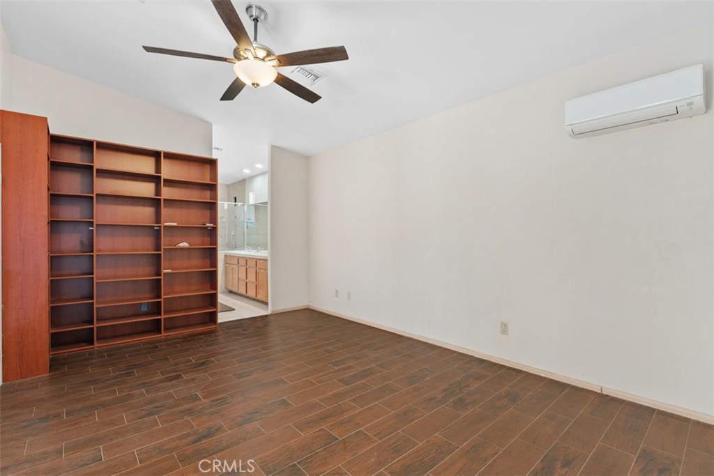 68744 Durango Road Cathedral City, CA 92234 - Photo 27 of 36 a view of an empty room with a ceiling fan and wooden floor
