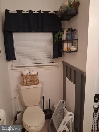 a bathroom with a toilet a sink and a window