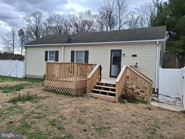 a view of a balcony with wooden floor and fence next to a yard