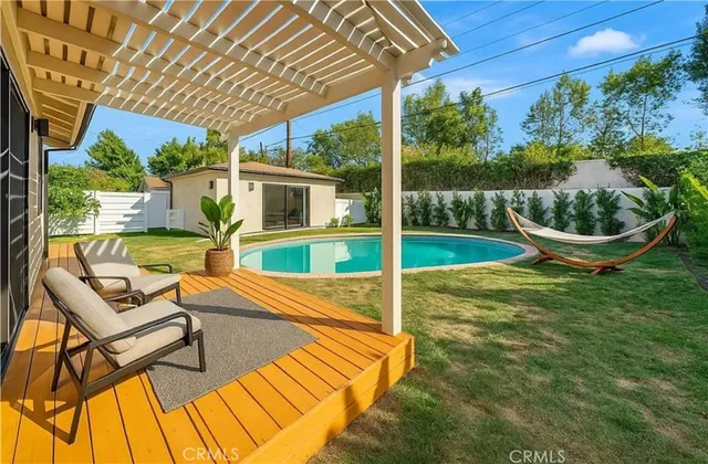 a view of a house with backyard and sitting area