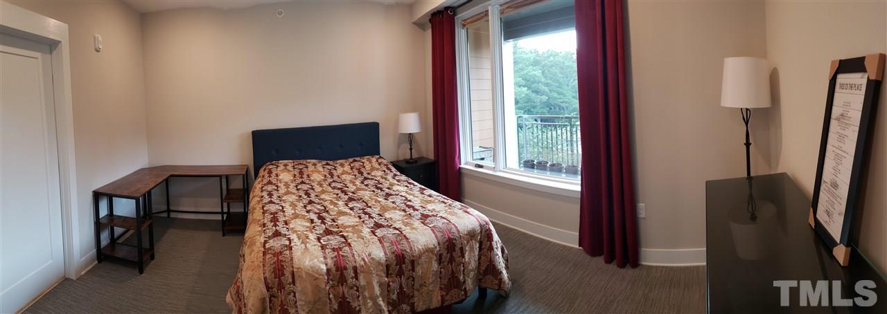 105 Chatham Walk Lane, Unit 404 Cary, NC 27511 - Photo 5 of 12 a bed sitting in a bedroom next to a window