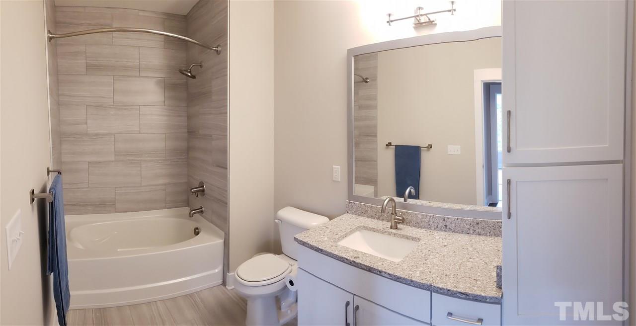105 Chatham Walk Lane, Unit 404 Cary, NC 27511 - Photo 10 of 12 a bathroom with a granite countertop sink a toilet and bathtub