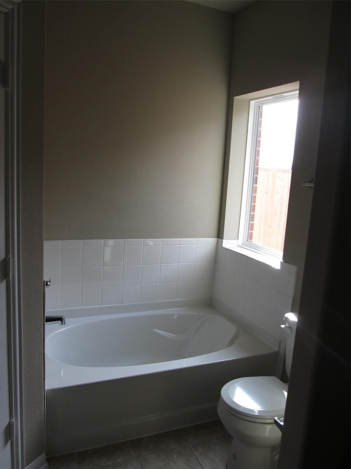 2310 Thunderbolt Peak Drive Rosharon, TX 77583 - Photo 17 of 27 a bathroom with a toilet and a bathtub