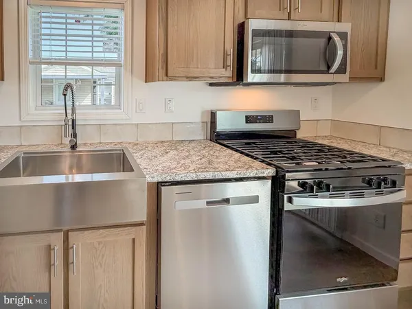 a kitchen with stainless steel appliances granite countertop a sink stove and microwave