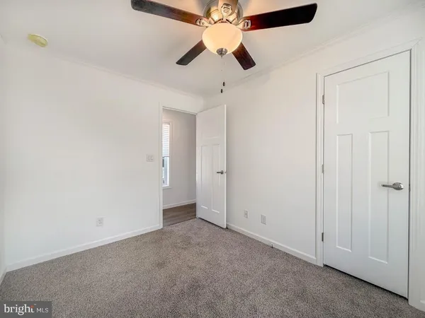 an empty room with a ceiling fan and a fan