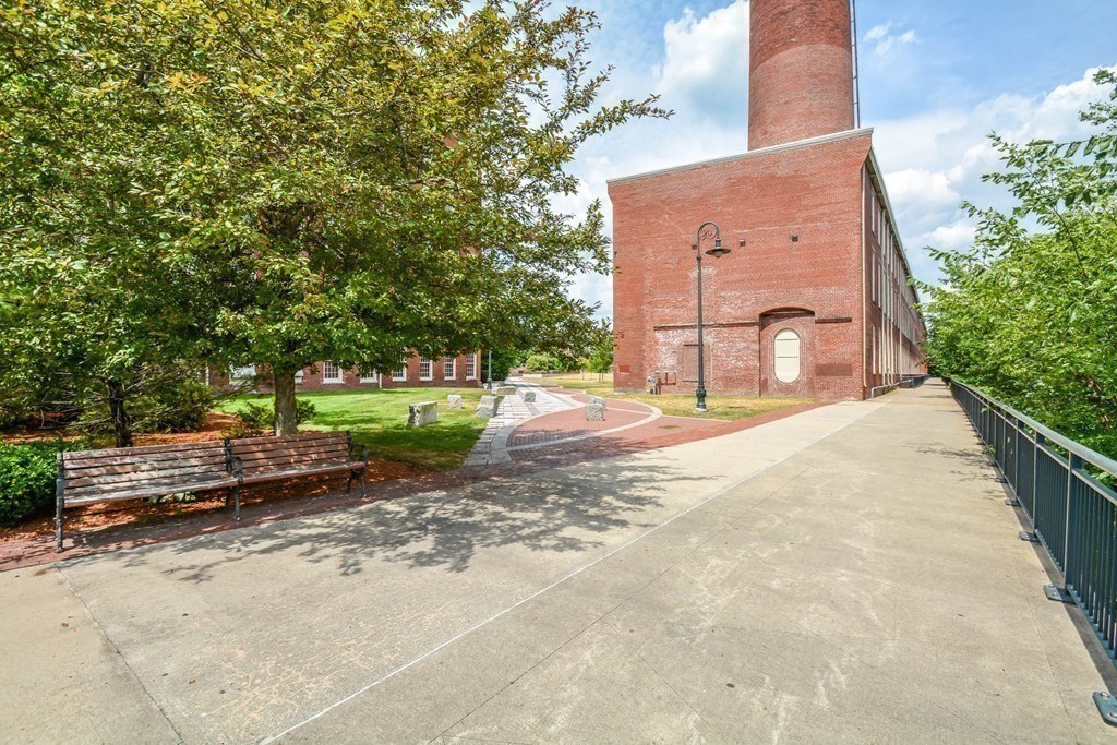 35 Riverwalk Way, Unit R302 Lowell, MA 01854 - Photo 19 of 20 a backyard of a house with barbeque oven and a fountain
