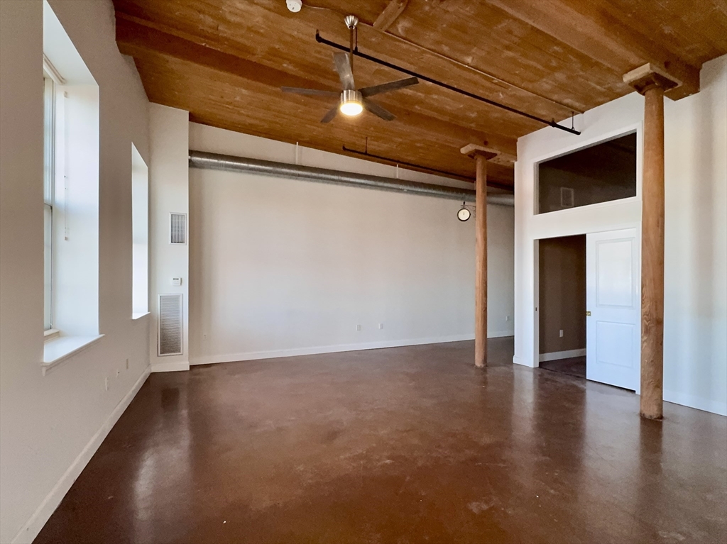 35 Riverwalk Way, Unit R302 Lowell, MA 01854 - Photo 4 of 20 a view of an empty room with wooden floor and a window