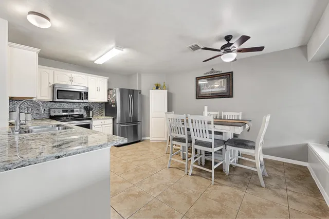 a view of a dining room kitchen with furniture and a ceiling fan