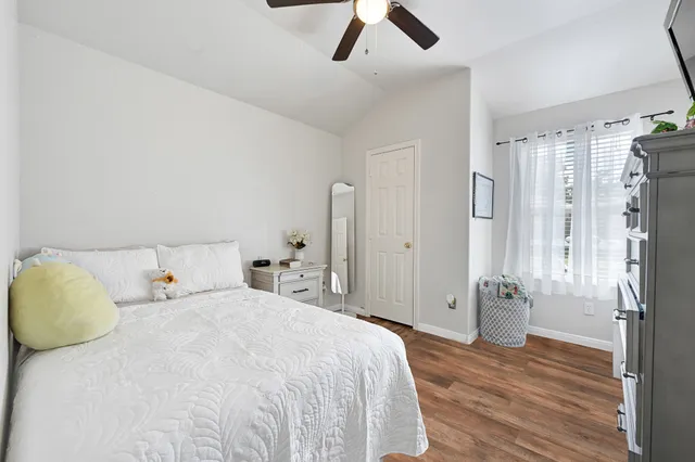 a bedroom with a bed closet and wooden floor