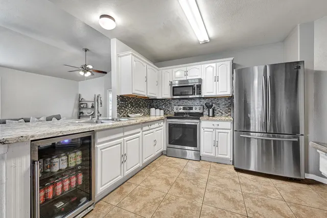 a kitchen with kitchen island stainless steel appliances cabinets a sink and a counter top space