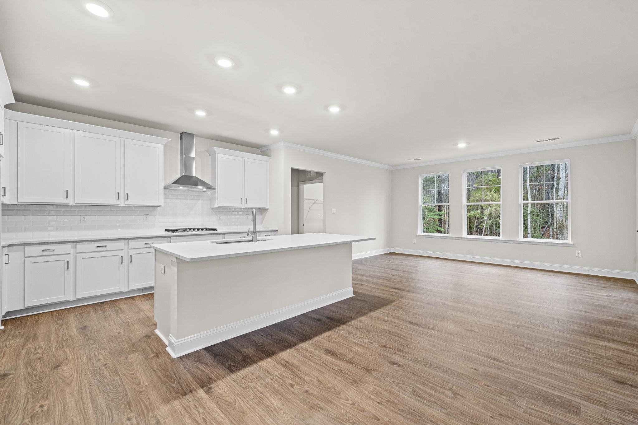 128 Jaspers Lane Stuarts Draft, VA 24477 - Photo 9 of 26 a large kitchen with wooden floors and white cabinets