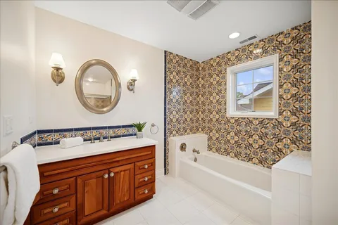 a bathroom with a bathtub sink and mirror