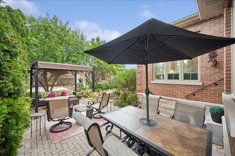 a view of a patio with table and chairs under an umbrella