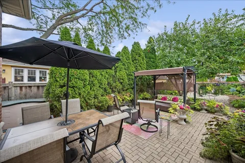 a view of backyard with table and chairs under an umbrella