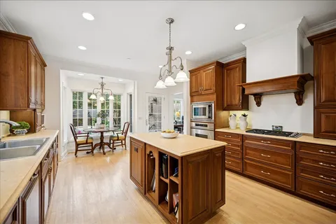 a open kitchen with stainless steel appliances granite countertop a stove top oven a refrigerator a sink and dishwasher with wooden floor