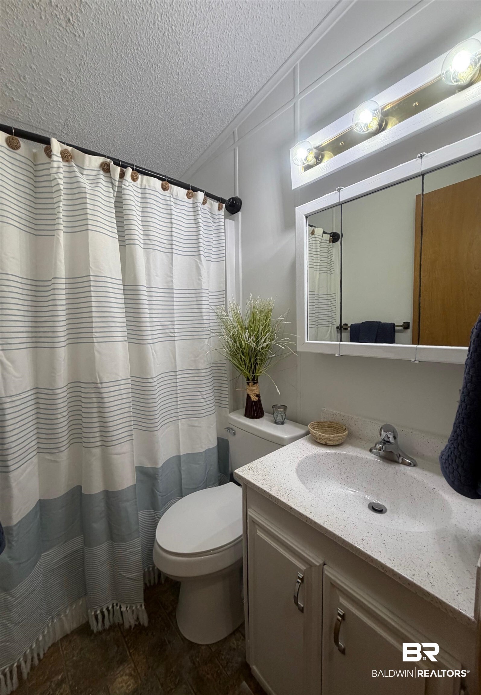 685 Escambia Loop Lillian, AL 36549 - Photo 12 of 43 Full bath with vanity, a shower with shower curtain, and a textured ceiling