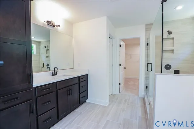 a spacious bathroom with a double vanity sink a mirror and shower