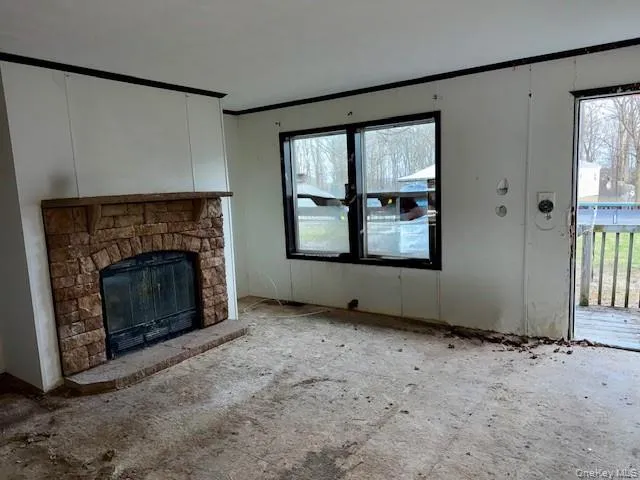 an empty room with windows and fireplace