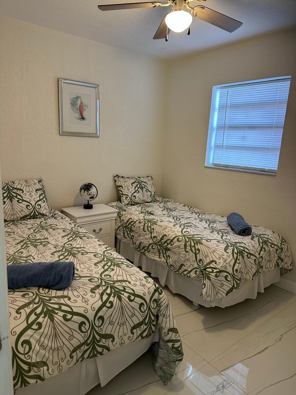 5131 Southwest 6th Court Margate, FL 33068 - Photo 17 of 25 a bedroom with two beds and a chandelier