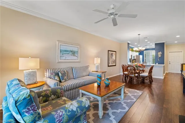 a living room with furniture a chandelier and a dining table