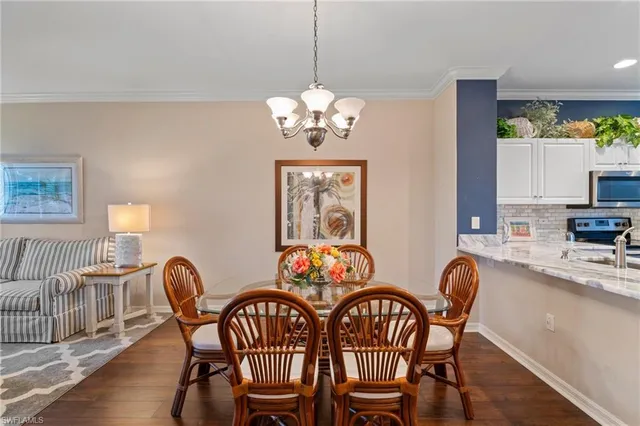 a view of a dining room with furniture a chandelier and wooden floor