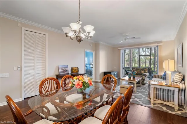a view of a dining room with furniture a chandelier and wooden floor